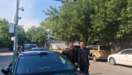 黄仁勋与雷军合影,35度天气仍穿皮衣!两人站在一辆小米汽车前,面带微笑,显得十分亲切